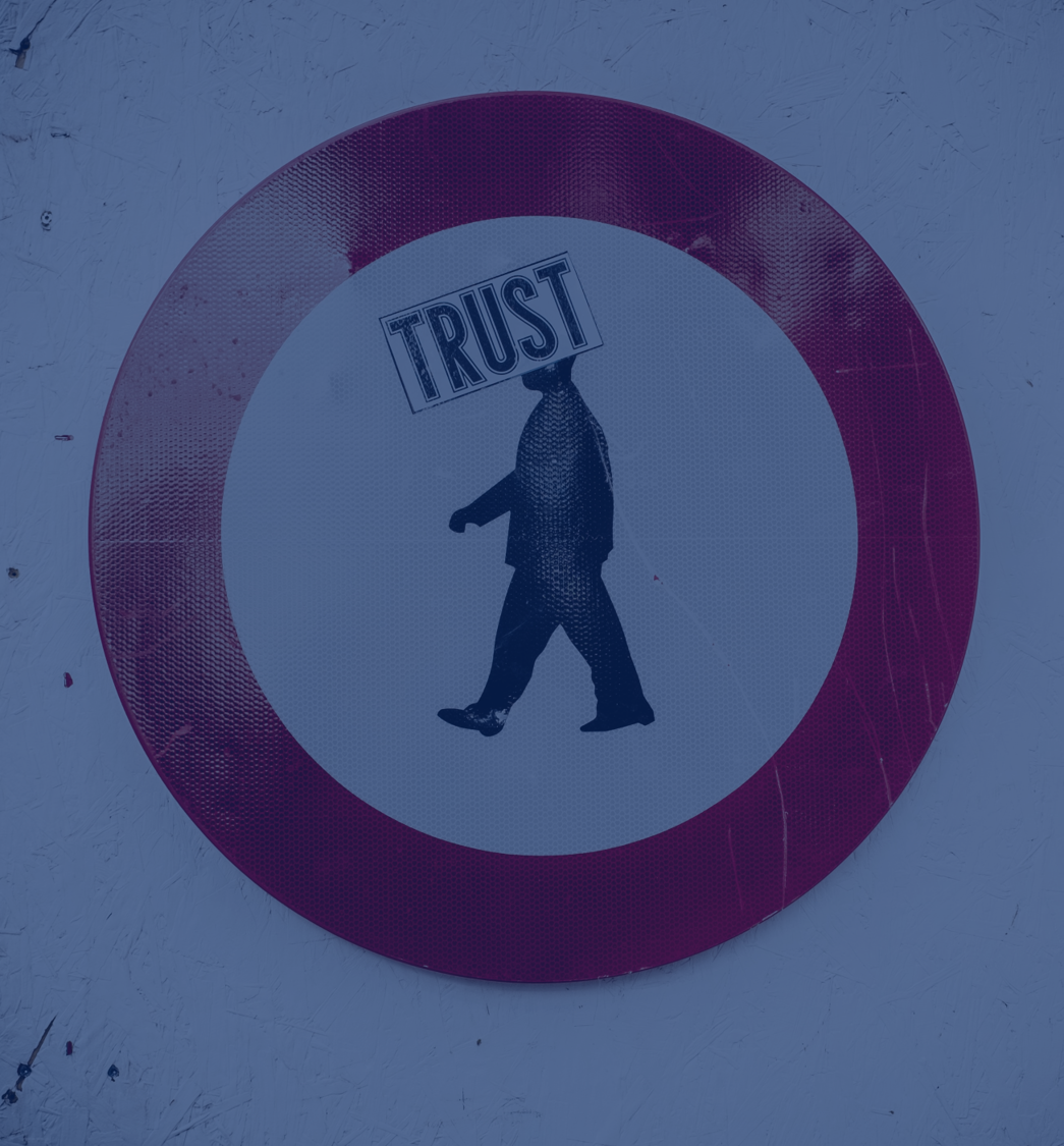 A imagem mostra uma placa, com o ícone de um homem andando dentro. No lugar de sua cabeça, há a palavra "trust" confiança, em português).
