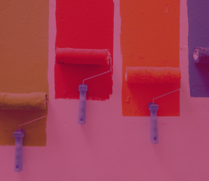 A imagem mostra uma parede sendo pintada com diferentes cores.