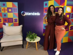 Thalita Gelenske e Débora Montibeler, do time da Blend, em frente a uma estrutura montada para apresentação do Summit