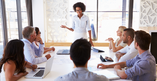 Imagem de 8 pessoas reunidas num escritório corporativo