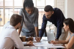 Quatro profissionais reunidos no ambiente de trabalho